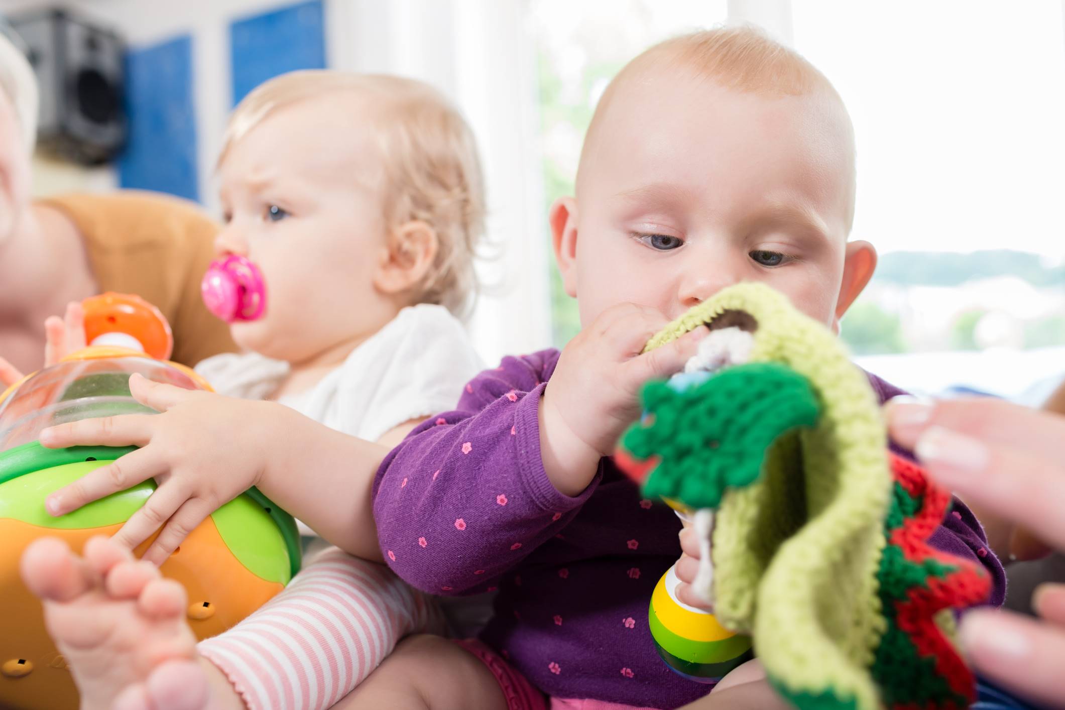 Babies playing with soft toys